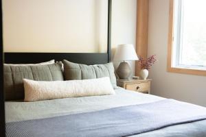 ein Bett mit einer blauen Decke und einer Lampe auf einem Tisch in der Unterkunft Black Rock Lodge in Stowe