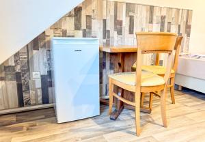 BunkenburgRuime accommodatie voor 10 personen in Marx的一张桌子旁边放着一台冰箱和一把椅子。 更多23张照片