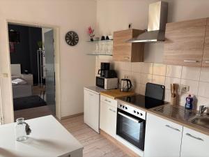 a kitchen with white cabinets and a stove top oven at Parkblick in Wittenberge