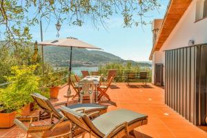 a patio with chairs and a table with an umbrella at La dimora dell'artista sea view free parking in San Terenzo