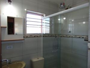 a bathroom with a shower and a toilet and a sink at Vila Secreta in Campos do Jordão