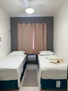 two twin beds in a room with a window at Apartamento Belem Cop30 proximo ao aeroporto #belem #Cop 30 #aeroporto in Belém