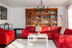 a living room with a red couch and a book shelf at Ferienhaus Eisenach in Eisenach