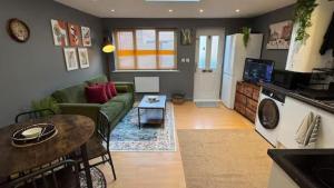 ein Wohnzimmer mit einer grünen Couch und einem Tisch in der Unterkunft Watford High Street apartment with kitchen & sofa bed in Watford