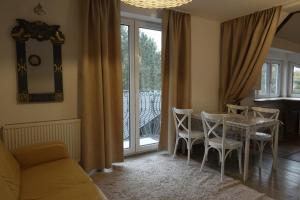 ein Wohnzimmer mit Esstisch und Stühlen in der Unterkunft Millanova in Milanówek