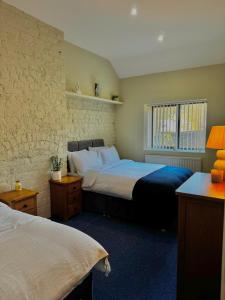 ein Schlafzimmer mit zwei Betten und einem Fenster in der Unterkunft Mallview Coach House in Armagh