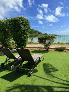 two chairs sitting on the grass in a yard at Maison bord de mer in Le Gosier