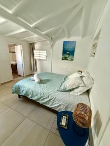 a bedroom with a bed and a table in it at Maison bord de mer in Le Gosier +21 photos