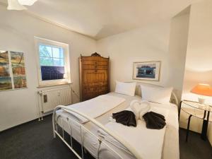 a bedroom with a white bed with a heart on it at Ostseeloft Wischuer in Rerik