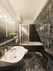 a bathroom with a white sink and a tub at Ostseeloft Wischuer in Rerik +23 photos