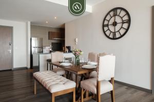 a dining room with a table and chairs and a clock at 1BR Condo in Polanco - Pool - Coworking - CityView in Mexico City
