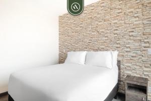 a bedroom with a white bed and a brick wall at 1BR Condo in Polanco - Pool - Coworking - CityView in Mexico City +16 photos