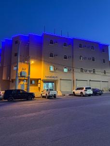 a large building with cars parked in front of it at شقق رفيف الشمال المخدومه - الحائط Alhayit -Rafeef Al Shamal رفيف الشمال شقق مخدومه - الحائط in Al Ḩāyiţ