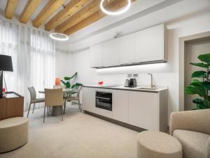 a kitchen with white cabinets and a table with chairs at Palazzo Degli Eletti R&R in Venice