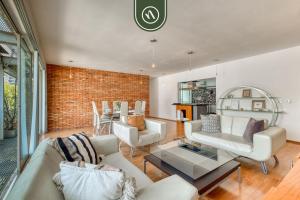 a living room with white furniture and a brick wall at Centric 2 BR Condo - Roma - Rio de Janeiro Park in Mexico City +26 photos
