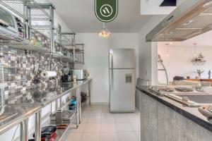 a large kitchen with a refrigerator in the middle at Centric 2 BR Condo - Roma - Rio de Janeiro Park in Mexico City
