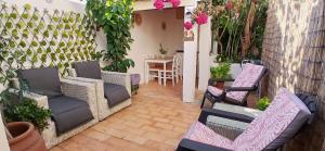 een patio met rieten stoelen en een tafel in de tuin bij Casa Rustica - Courtyard House in Olhão
