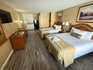 a hotel room with two beds and a flat screen tv at Viking Motel in Myrtle Beach