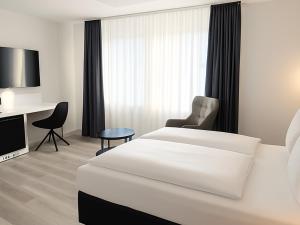 a hotel room with a bed and a desk at DORMERO Hotel Dessau-Roßlau in Dessau