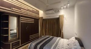 a bedroom with a bed and a dresser and a mirror at RR Villa in Bantvāl