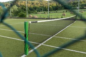 a tennis net on a tennis court at Pensiunea Carol Oglinzi in Oglinzi +23 photos