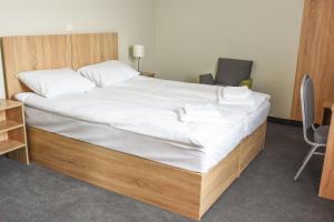 a bedroom with a large bed with white sheets at ARGENTIA noclegi in Dzierżoniów