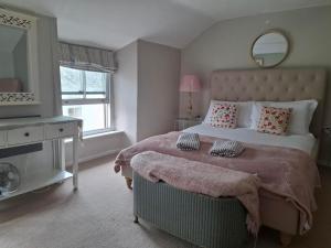 una camera da letto con un letto grande e uno specchio di The Samphire Cottage a Porthleven