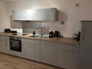 a kitchen with white cabinets and a sink at Ferienwohnung Am Sonnenrain in Albshausen