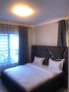 a bed with two pillows on it in a bedroom at McMillan Hotel in Entebbe