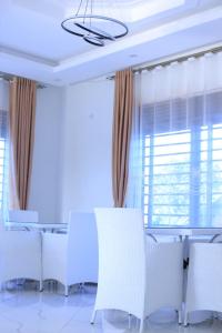 a dining room with white chairs and a table at McMillan Hotel in Entebbe