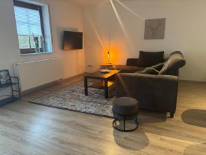 a living room with a couch and a table at Ferienwohnung Am Sonnenrain in Albshausen