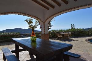 a wooden table with a vase on top of a patio at Finca Higueron with private Pool in Río