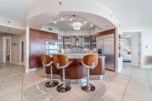 une cuisine ouverte avec un bar et des tabourets dans l'établissement Bella Luna 205, à Perdido Key
