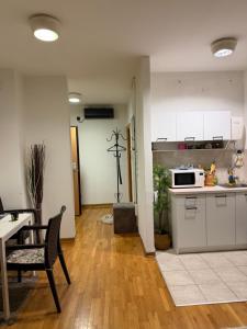 a kitchen with white cabinets and a table and a microwave at Belgrade with love in Novi Beograd +7 photos