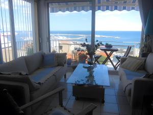 a living room with couches and a table with a view at Chambre d'hôtes - Le quartier haut in Sète +14 photos