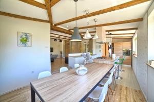 a dining room and kitchen with a wooden table and chairs at Villa Nikolina in Šišan