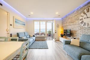 a living room with a large clock on a brick wall at Una spettacolare vista mare - Casa con Jacuzzi in Bergeggi