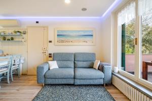 a living room with a blue couch and a table at Una spettacolare vista mare - Casa con Jacuzzi in Bergeggi