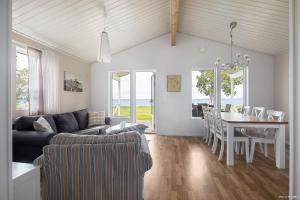 a living room with a couch and a dining room table at First Camp Vadstena - Vättern in Vadstena