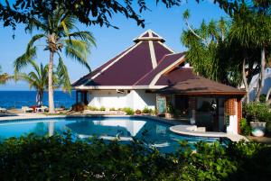 a resort with a swimming pool in front of the ocean at Quo Vadis Dive Resort in Moalboal