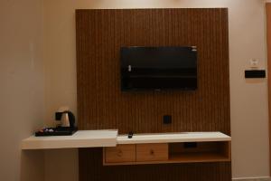a flat screen tv hanging on a wall with a counter at Hotel RS Grand in Kashi
