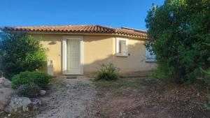a small yellow house with a white door at Villa Résidence San Martinu Sainte Lucie De Porto Vecchio in Zonza