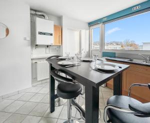 a kitchen with a table and chairs in a kitchen at Vue panoramique sur la plage, grand T2 in Dunkerque