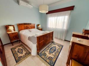 a bedroom with a bed and two rugs at Casa dos Pomares in Figueira da Foz