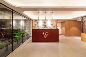 a lobby with a reception desk with a gold vase at Hotel Vaari Vista By Bestinn Leisure in Bengaluru