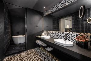 a bathroom with two sinks and a tub and a mirror at 烟台朝阳文保艺术酒店 in Yantai +15 photos