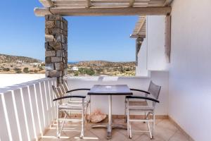 a patio with a table and chairs on a balcony at Harama Hotel Schinousa in Schinoussa