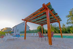 a wooden pavilion with chairs and a table at Ferienhaus In Opanci Mit Beheiztem Pool, Parkplatz in Lovreć