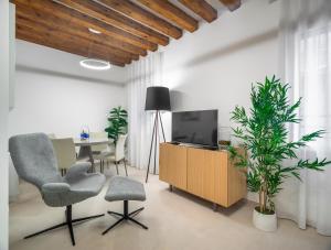 a living room with a table and chairs and a television at Palazzo Degli Eletti R&R in Venice