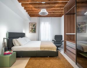 a bedroom with a bed and a desk and a chair at Palazzo Degli Eletti R&R in Venice